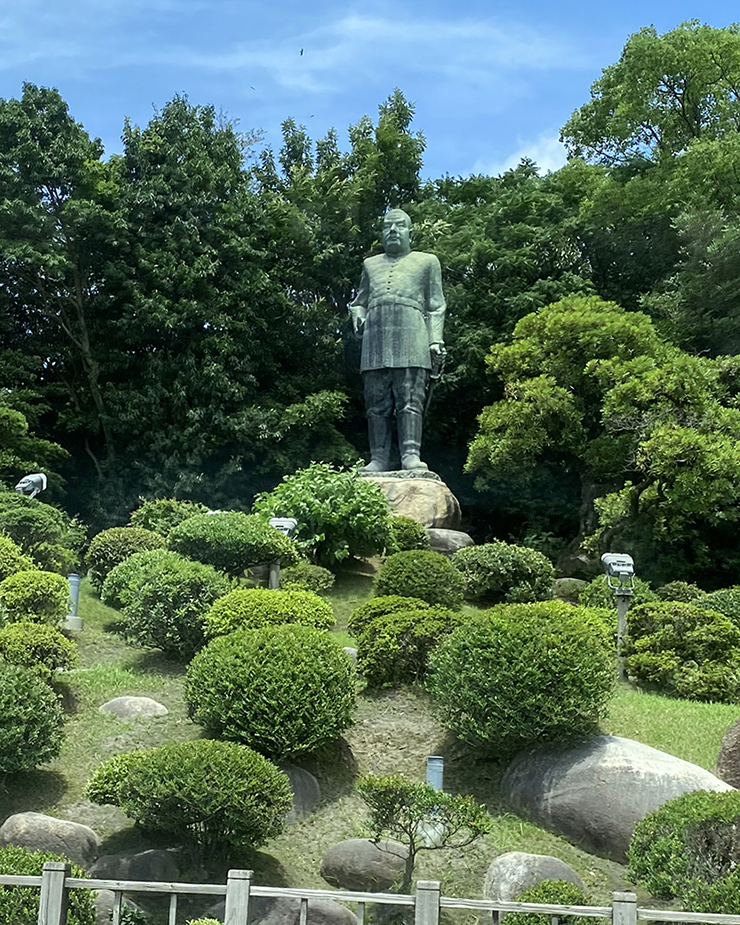 城山をバックに立つ「西郷銅像」